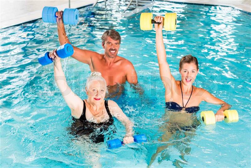 Group of people, mature man, young and senior women, at water gymnastics or aquarobics, stock photo