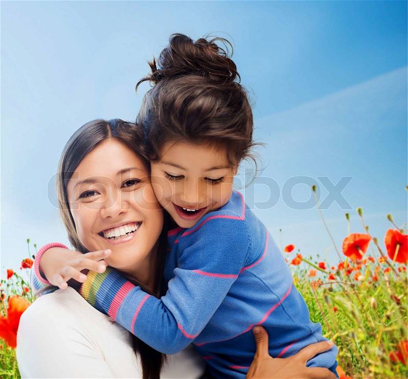 People, happiness, love, family and motherhood concept - happy mother and daughter hugging over blue sky and poppy field background, stock photo