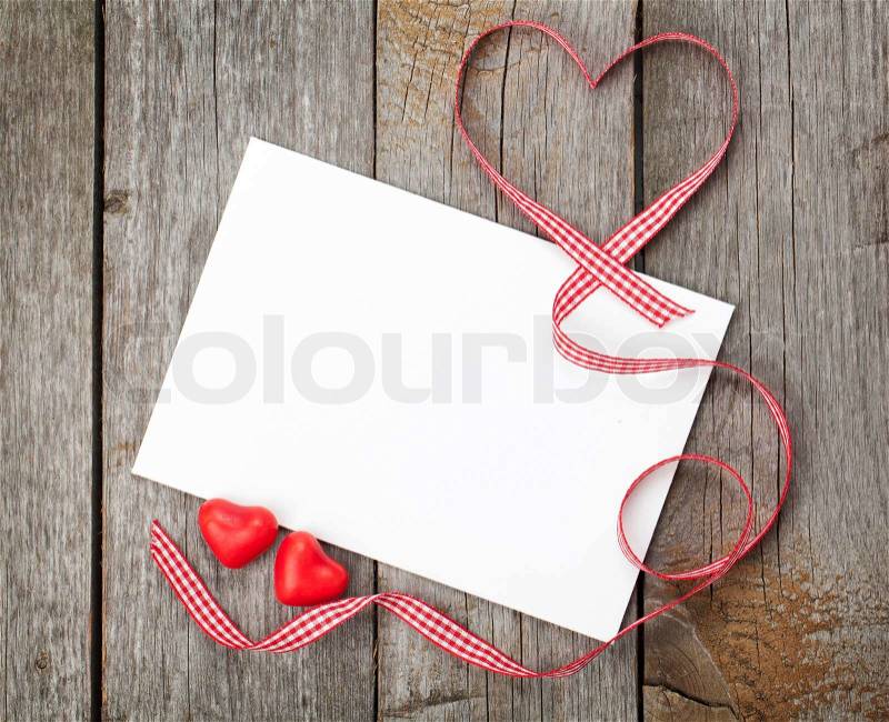 Valentine\'s day blank gift card and red candy hearts on wooden background, stock photo