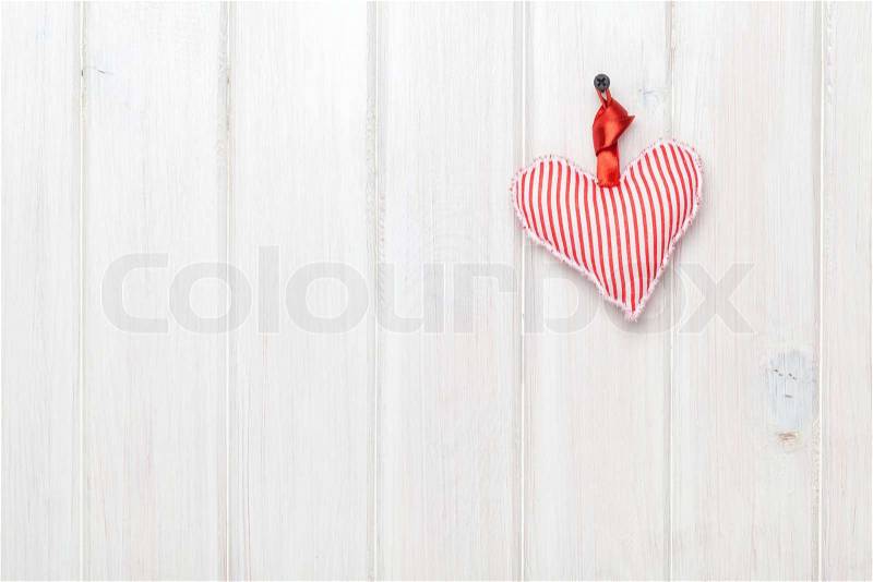 Valentines day background with toy heart over white wooden table, stock photo