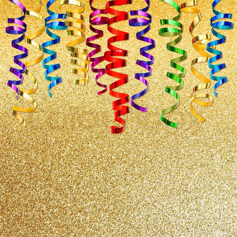 Colorful streamer over golden shiny background. party decoration, stock photo