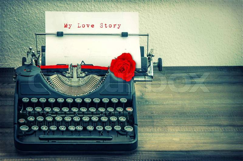 Vintage typewriter with white paper and red rose flower. Sample text My Love Story. Vintage style toned grungy picture, stock photo