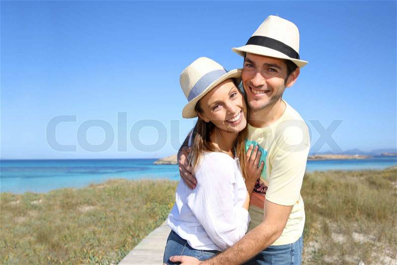 Portrait of sweet couple embracing by the beach, stock photo