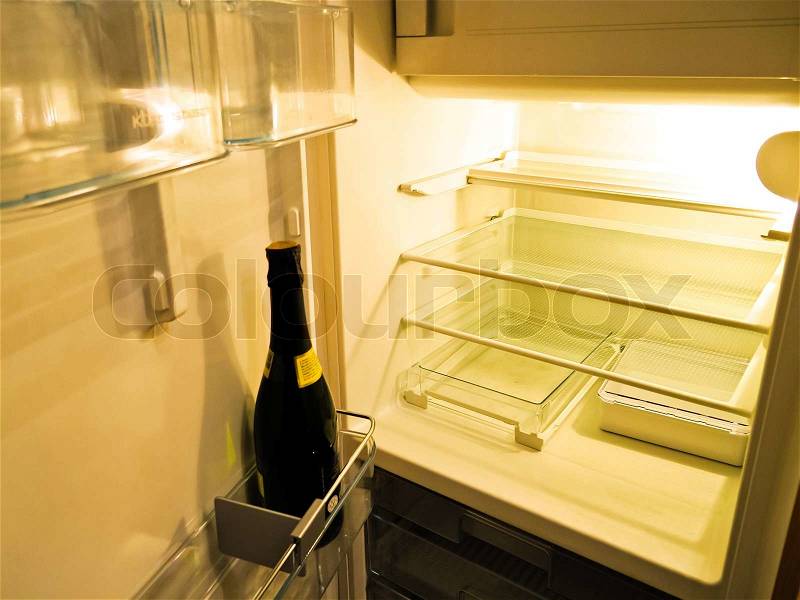 Empty fridge with a bottle of champagne to detach and diets, stock photo