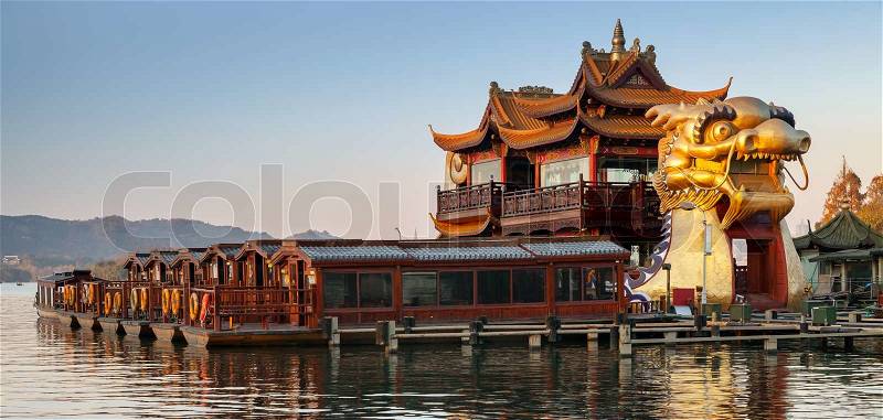 Hangzhou, China - December 5, 2014: Chinese wooden recreation boats and Dragon ship are moored on the West Lake. Famous park in Hangzhou city center, China, stock photo