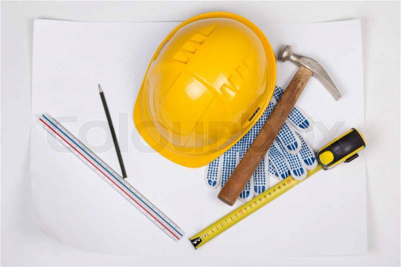 Yellow builder\'s helmet and work tools over white background, stock photo