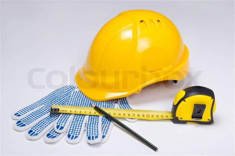 Builder\'s tools - helmet, work gloves, pen and measure tape over white background, stock photo