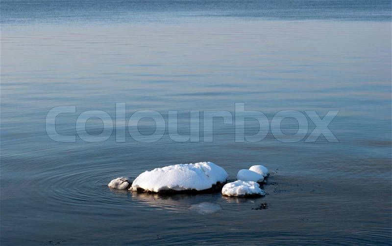 Danish sea in winter time. Stones in the water with white snow, stock photo