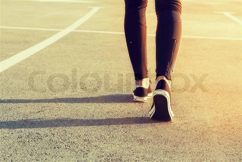 Sport legs girl sneakers on the pavement, stock photo