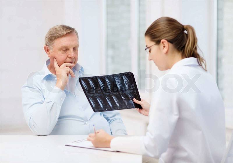 Healthcare, medicine and elderly concept - female doctor with old man looking at x-ray, stock photo
