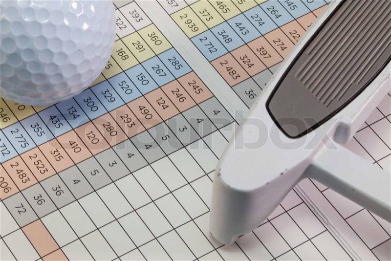 Golf putter and other equipments lying on a golf score card, stock photo