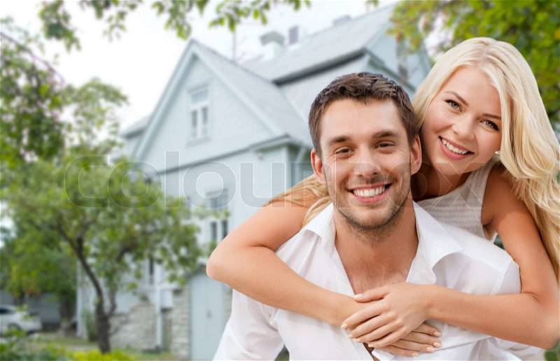 Love, people, real estate, home and family concept - smiling couple hugging over house background, stock photo