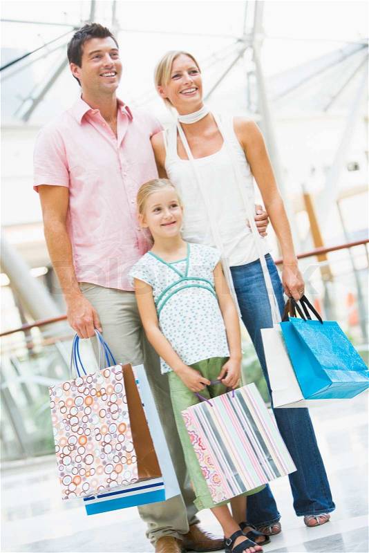 Family shopping in mall carrying bags, stock photo