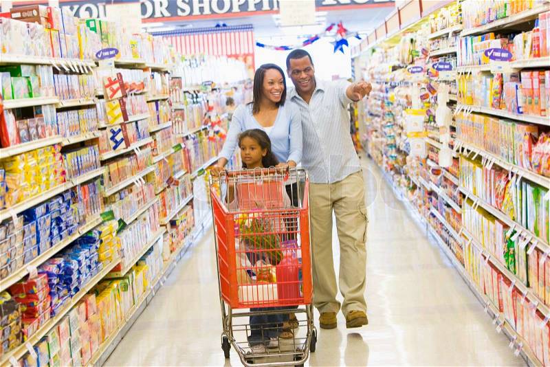 Young family grocery shopping in supermarket, stock photo