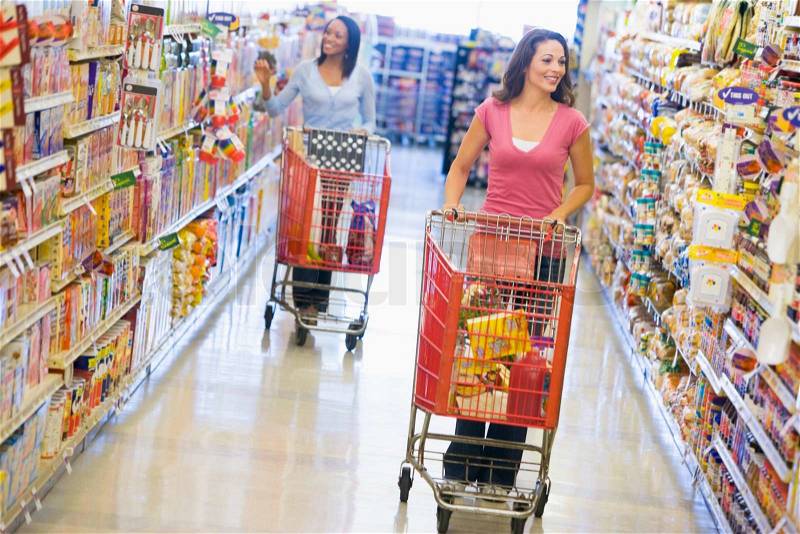 Women grocery shopping in supermarket, stock photo