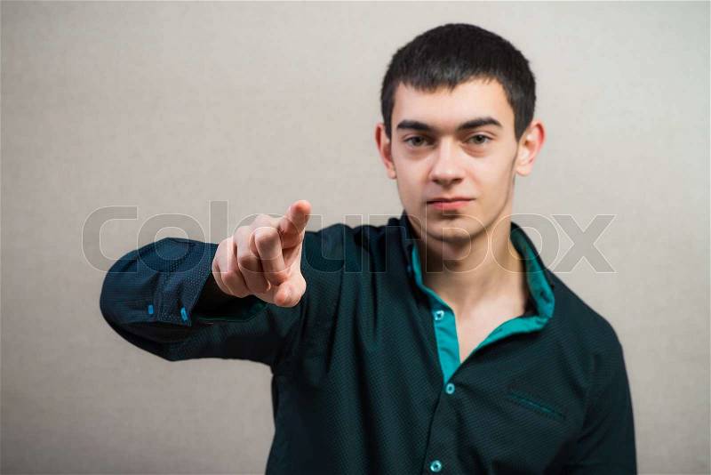 Casual young man pointing up, stock photo