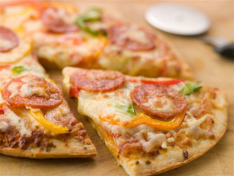 CLose up of Pepperoni and Pepper Pizza with a Pizza Cutter, stock photo