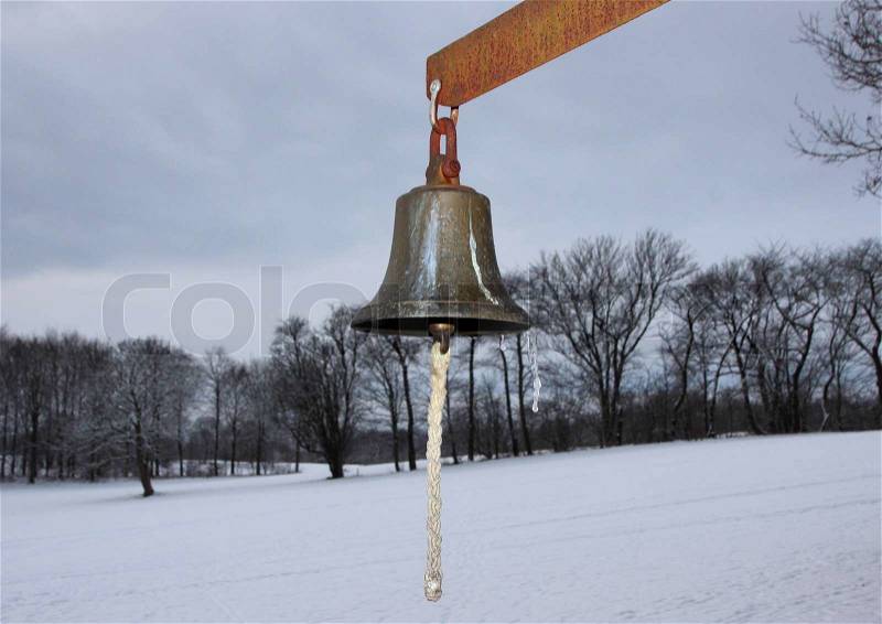 Metal Bell with Winter Snowy Fields in Background. The Bell is used on a golf course, stock photo