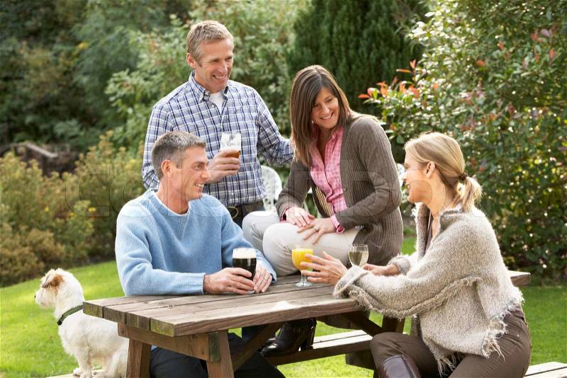 Group Of Friends Outdoors Enjoying Drink In Pub Garden, stock photo