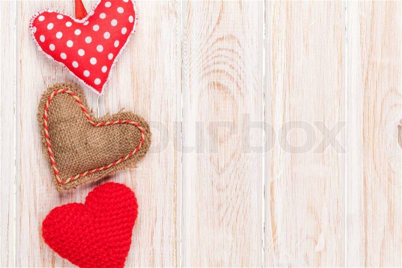 Valentines day background with toy hearts over white wooden table, stock photo