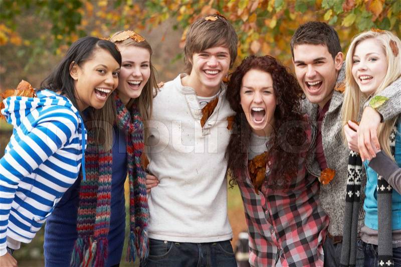 Group Of Six Teenage Friends Having Fun In Autumn Park, stock photo