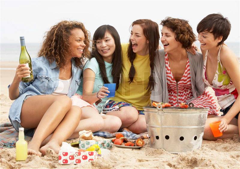 Group Of Girls Enjoying Barbeque On Beach Together, stock photo