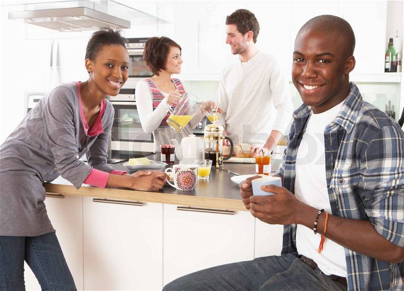 Group Of Young Friends Preparing Breakfast In Modern Kitchen, stock photo