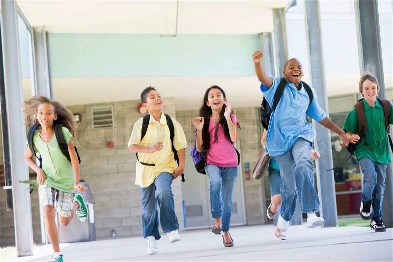 Elementary school pupils running outside together, stock photo