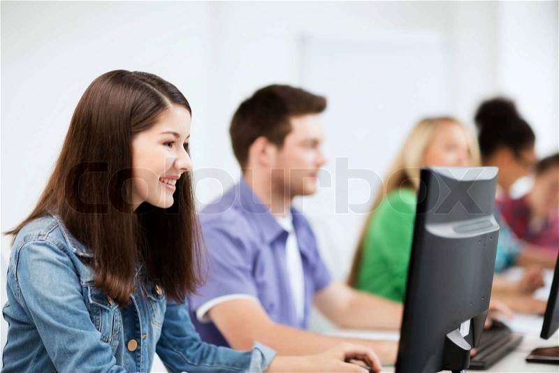 Education, technology and internet - students with computers studying at school, stock photo