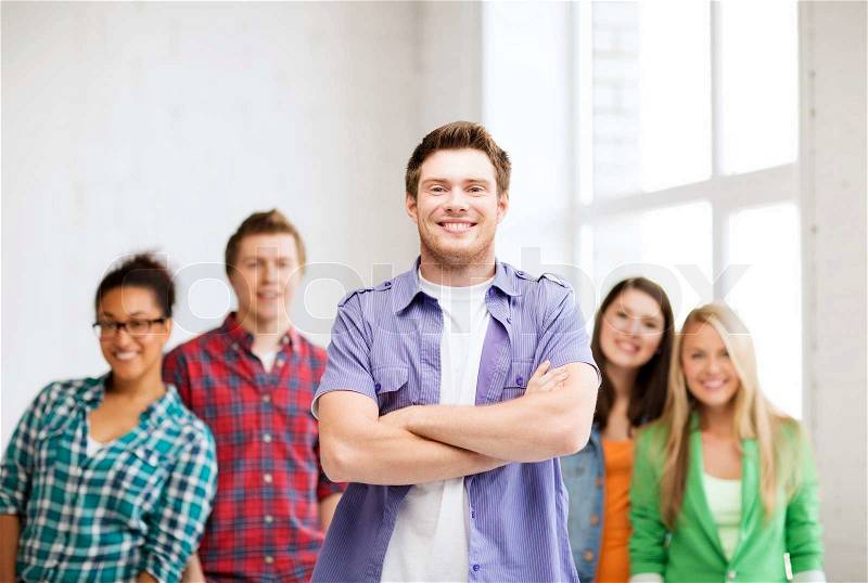 Education concept - student boy with group of students at school, stock photo