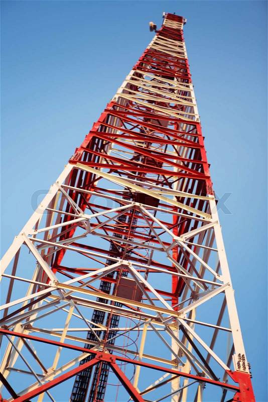 Red and white communication tower on blue sky, stock photo