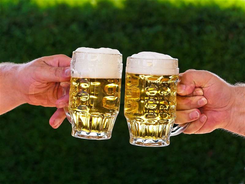 Two pitchers of beer we drink a toast with beer foam, stock photo