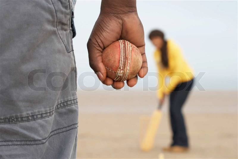 Young Couple Playing Cricket On Autumn Beach Holiday, stock photo