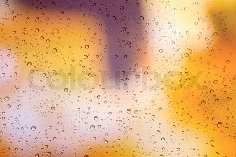 Drops of rain on window with bokeh lights background, stock photo