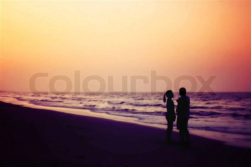 Silhouette of couples hugging on the beach on the beach with sunrise in the sea for valentine\'s day, stock photo