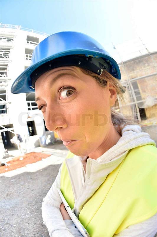 Woman architect on building site- funny face, stock photo