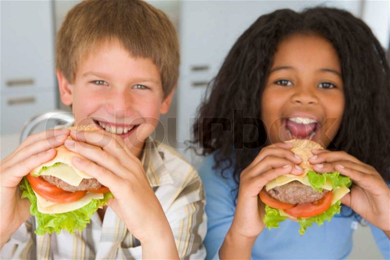 Boy and girl eating healthy burgers, stock photo