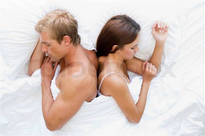Man and women in bed asleep, stock photo