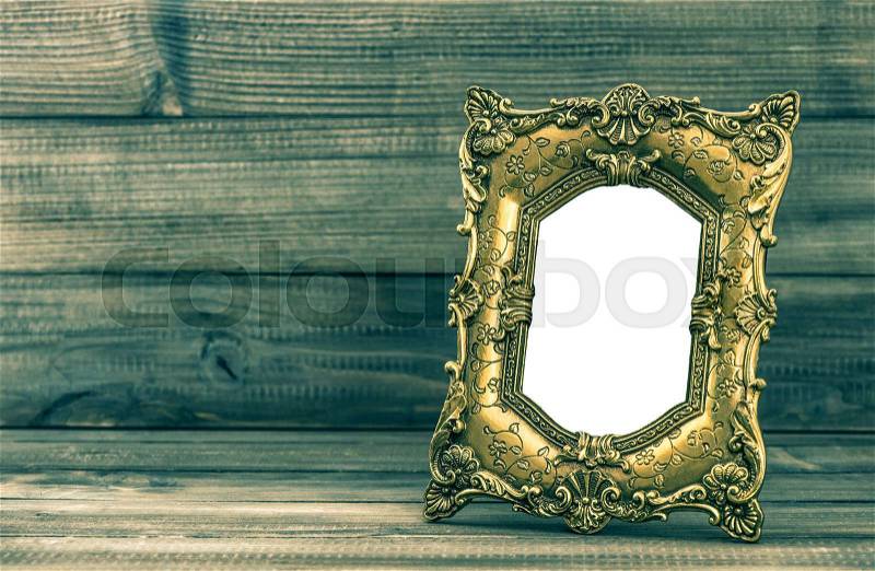 Golden baroque style frame on wooden background with place for your picture, stock photo