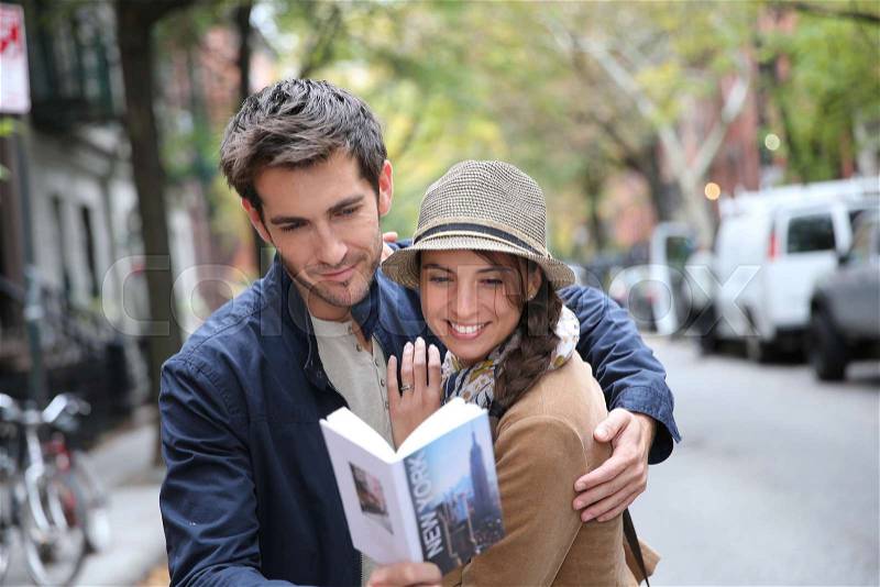 Couple with tourist guide book in Greenwich village, NYC, stock photo