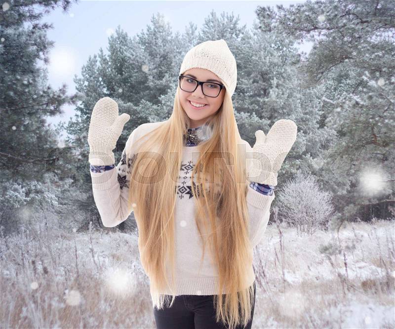 Happy young pretty woman in warm clothes walking in winter park, stock photo
