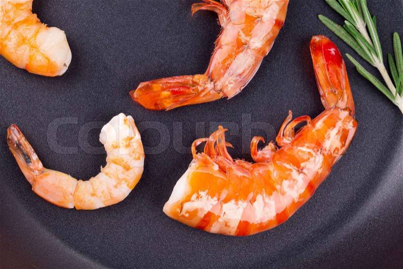 Tiger shrimps on black pan. Isolated on a white background, stock photo