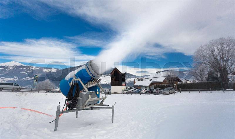 Making artificial snow on ski resort at cold day in Alps, stock photo