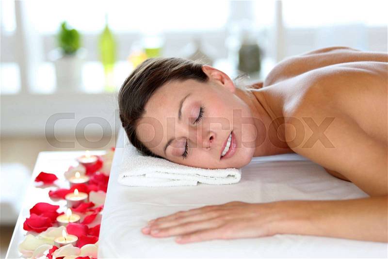 Beautiful girl receiving oil massage in beauty salon, stock photo