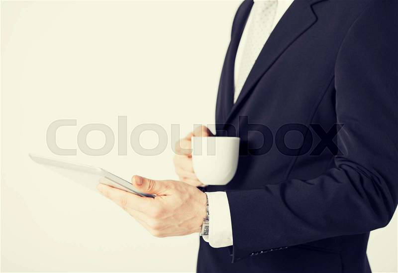Close up of man with tablet pc and cup of coffee, stock photo