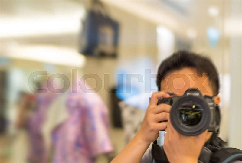 Tourist taking pictures with camera indoor, stock photo