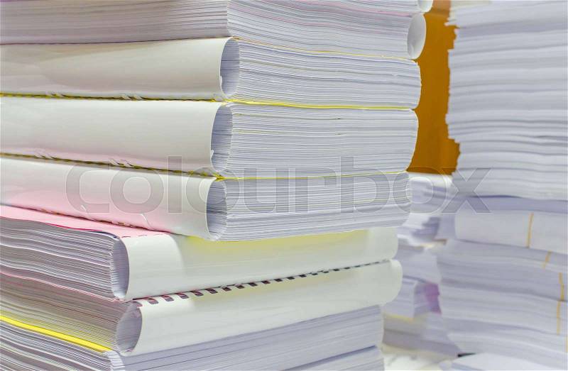 Pile of documents on desk stack up high waiting to be managed, stock photo