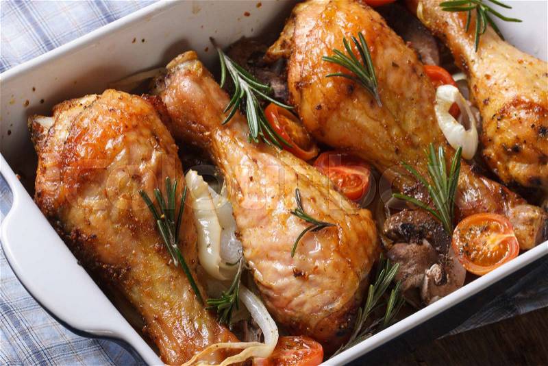 Chicken legs with mushrooms in a baking dish close up on the table. horizontal view from above , stock photo