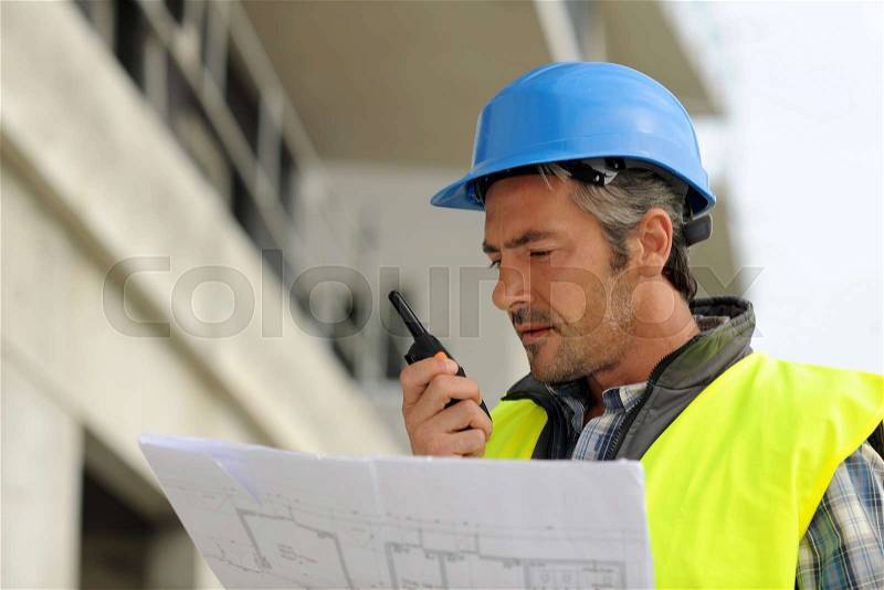 Portrait of construction manager using walkie-talkie, stock photo