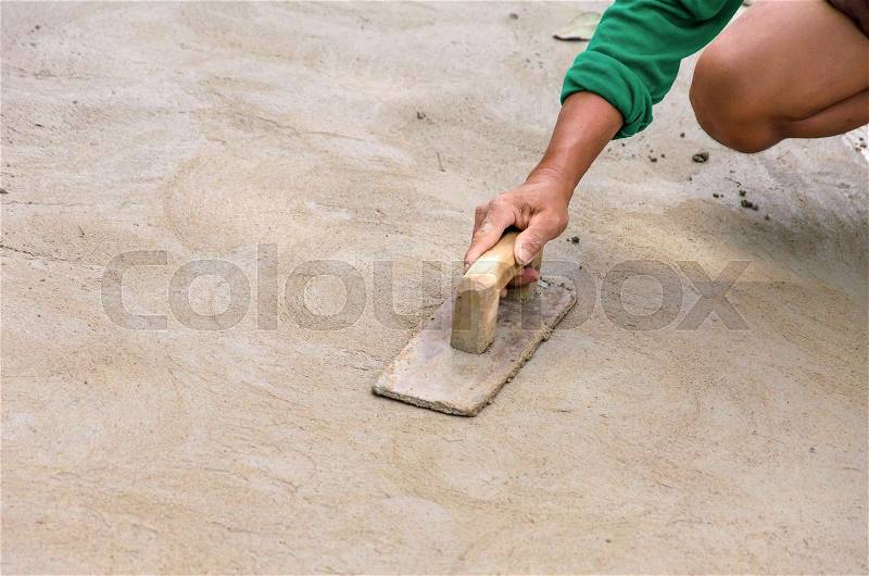 Plasterer concrete worker at floor of house construction, stock photo